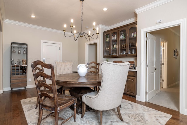 dining room featuring crown molding, baseboards, dark wood-style flooring, and a chandelier