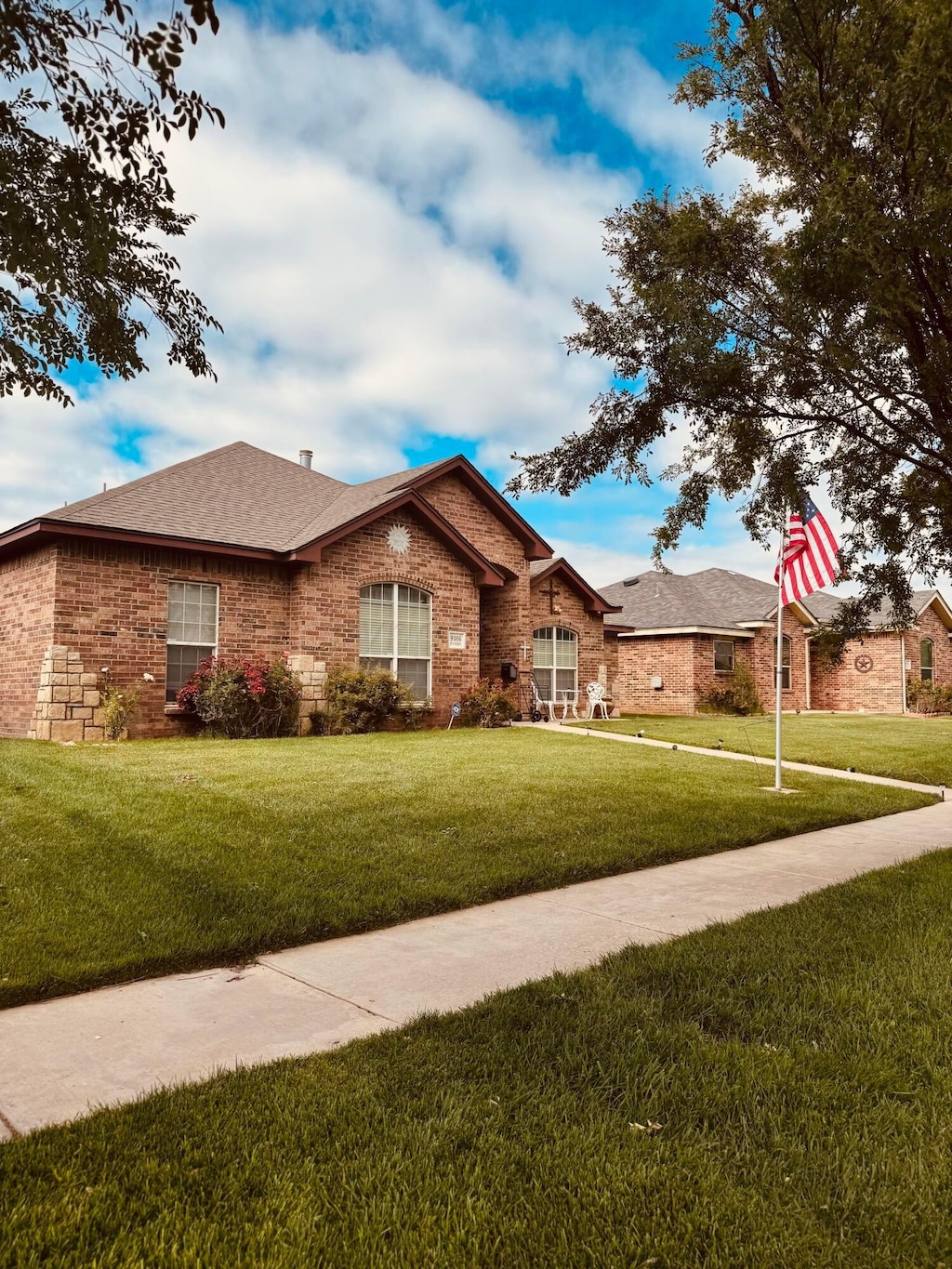 9306 Perry Ave, Amarillo, TX 79119 - ranch-style home with a front yard, brick siding, and roof with shingles