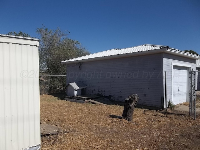 view of side of home featuring an outbuilding and a garage