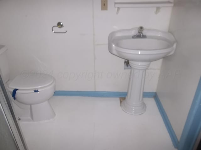 bathroom featuring toilet and tile patterned flooring