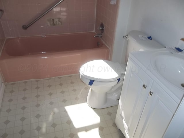 full bathroom featuring vanity, tiled shower / bath combo, and toilet