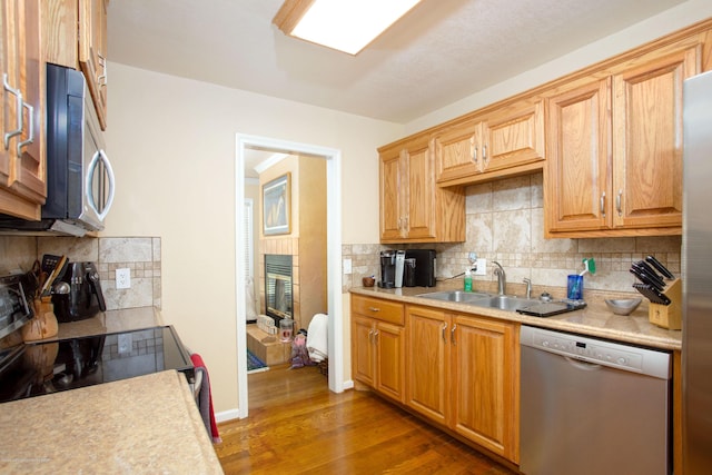 1219 S Rusk St, Amarillo, TX 79102 - kitchen with stainless steel appliances, backsplash, light countertops, and wood finished floors