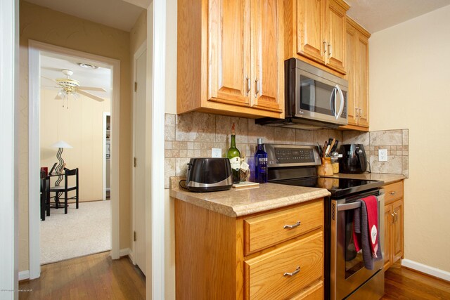 1219 S Rusk St, Amarillo, TX 79102 - kitchen with appliances with stainless steel finishes, light countertops, decorative backsplash, and dark wood-style flooring