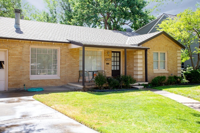 1219 S Rusk St, Amarillo, TX 79102 - ranch-style home with a porch, a front yard, brick siding, and a shingled roof