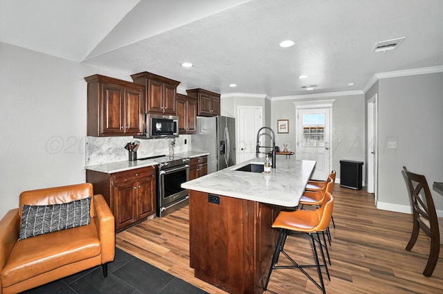 5001 Gloster St, Amarillo, TX 79118 - kitchen with stainless steel appliances, an island with sink, a sink, dark wood-style floors, and a breakfast bar area