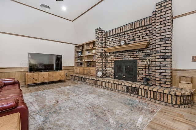 4012 Linda Dr, Amarillo, TX 79109 - living room with a wainscoted wall, wood finished floors, a fireplace, a high ceiling, and built in shelves