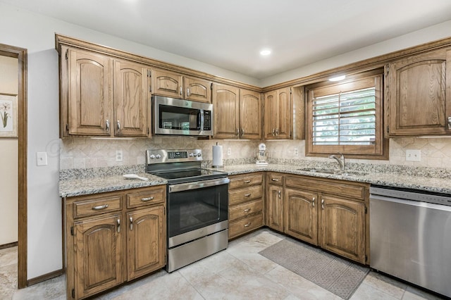 4012 Linda Dr, Amarillo, TX 79109 - kitchen with stainless steel appliances, decorative backsplash, light stone counters, and brown cabinets