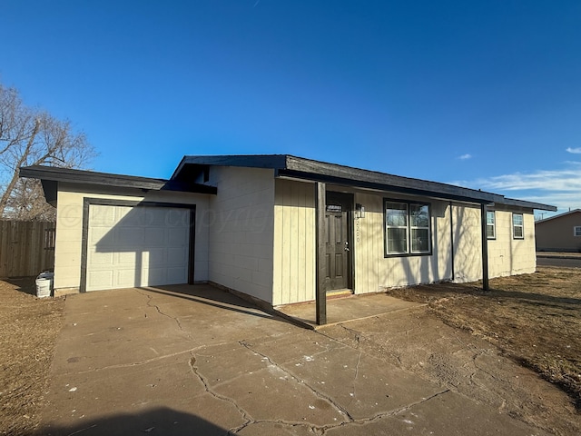 exterior space featuring an attached garage, driveway, and concrete block siding