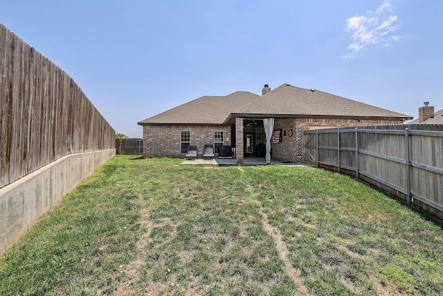 6702 Tatum Cir, Amarillo, TX 79119 - rear view of property featuring a patio area, brick siding, a fenced backyard, and a shingled roof