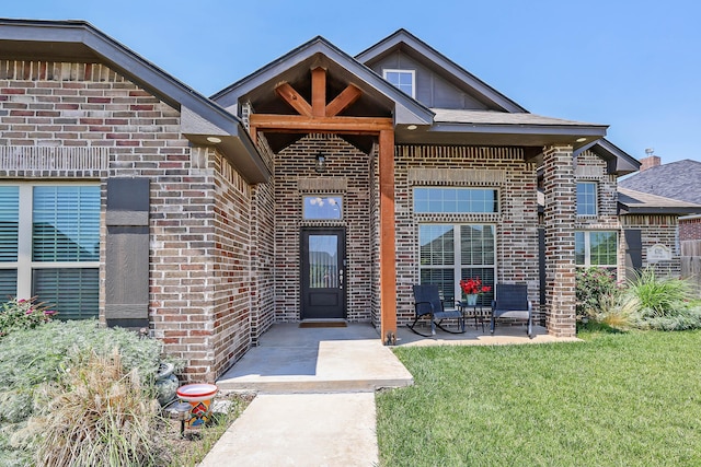 6702 Tatum Cir, Amarillo, TX 79119 - property entrance featuring brick siding, a patio area, and a lawn