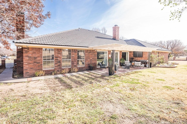 rear view of house featuring a lawn and a patio area