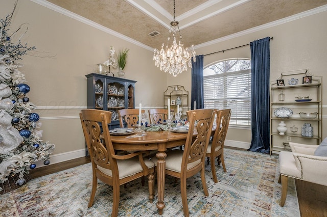 dining room featuring hardwood / wood-style flooring, crown molding, and an inviting chandelier