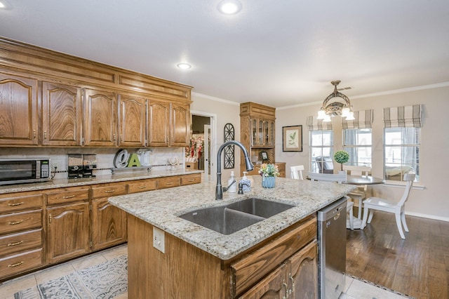 kitchen featuring a kitchen island with sink, an inviting chandelier, light hardwood / wood-style flooring, decorative light fixtures, and stainless steel appliances