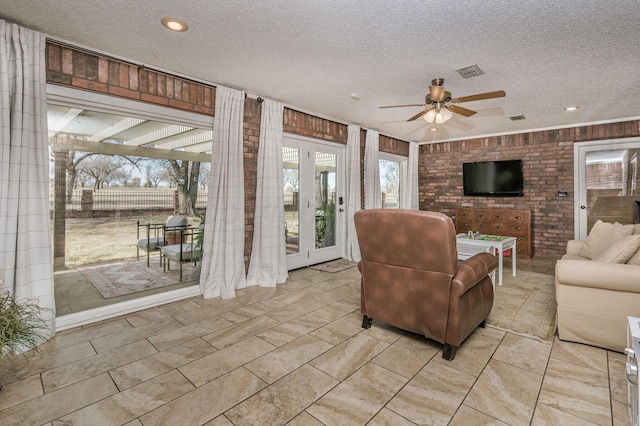 living room featuring ceiling fan and a textured ceiling