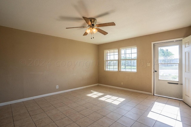 tiled spare room with ceiling fan and a textured ceiling