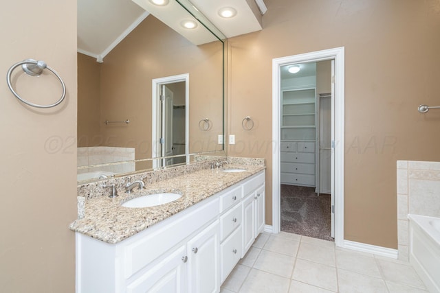 8309 Plymouth Dr, Amarillo, TX 79119 - bathroom featuring double vanity, a garden tub, tile patterned flooring, a spacious closet, and baseboards
