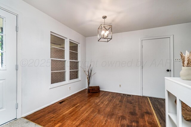 213 Union St, Borger, TX 79007 - unfurnished dining area featuring dark wood-style floors and a chandelier