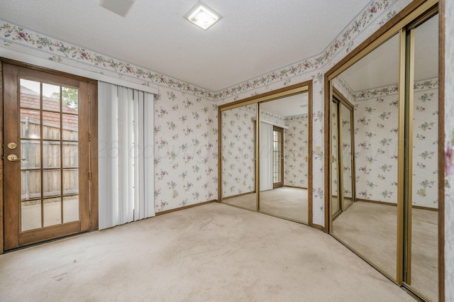 3457 Colchester Pl, Amarillo, TX 79121 - unfurnished bedroom with carpet flooring, a textured ceiling, two closets, and wallpapered walls