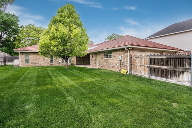 3457 Colchester Pl, Amarillo, TX 79121 - back of property featuring a lawn, brick siding, fence, and a tile roof