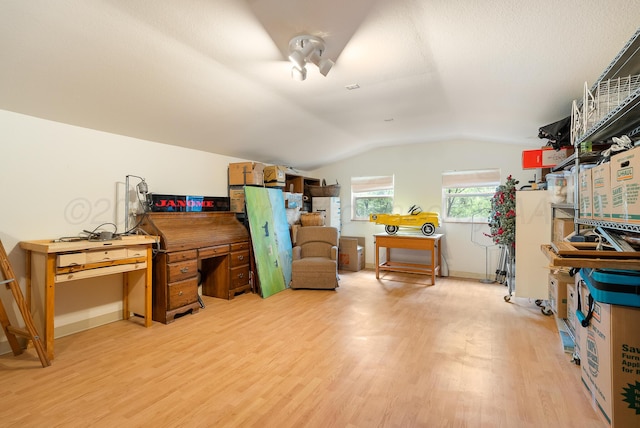 interior space featuring lofted ceiling, light wood-style flooring, and baseboards