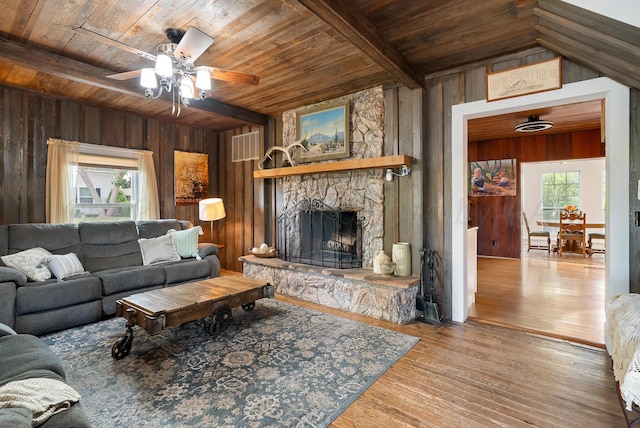 living room with a ceiling fan, wood walls, and wooden ceiling