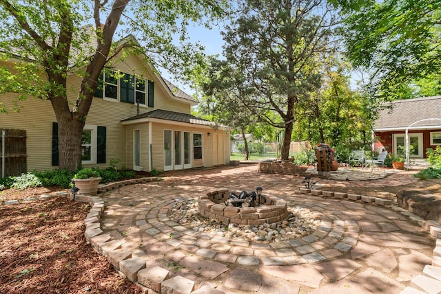 back of house with an outdoor fire pit, a patio, and fence