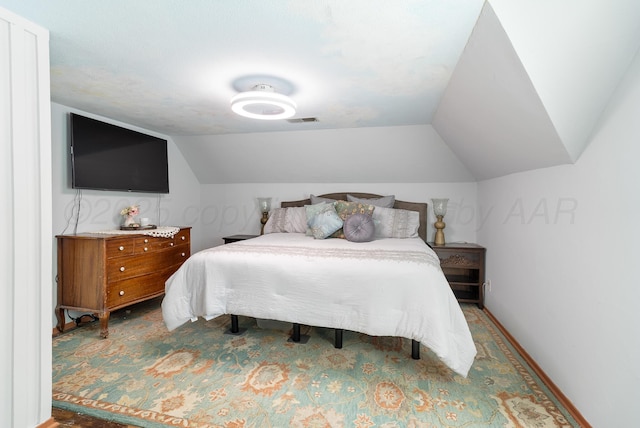 bedroom with baseboards, visible vents, carpet, and vaulted ceiling