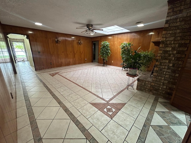 7906 Merchant Dr, Amarillo, TX 79121 - interior space featuring a skylight, wood walls, a textured ceiling, and ceiling fan
