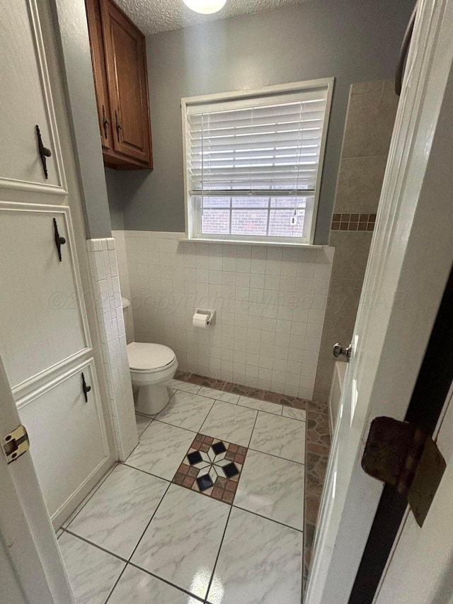 7906 Merchant Dr, Amarillo, TX 79121 - full bath featuring wainscoting, tile walls, marble finish floor, a shower, and toilet