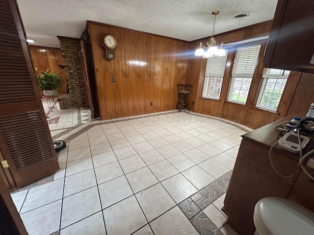 7906 Merchant Dr, Amarillo, TX 79121 - dining area featuring wooden walls, visible vents, a textured ceiling, and a notable chandelier
