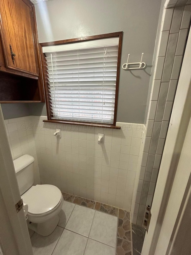 7906 Merchant Dr, Amarillo, TX 79121 - bathroom with wainscoting, toilet, tile patterned flooring, and tile walls