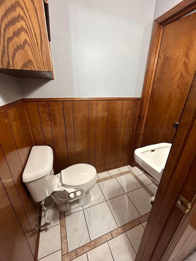 7906 Merchant Dr, Amarillo, TX 79121 - bathroom featuring wainscoting, marble finish floor, wood walls, and toilet