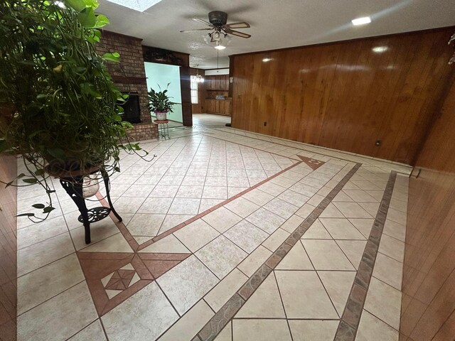 7906 Merchant Dr, Amarillo, TX 79121 - unfurnished living room featuring a ceiling fan, wooden walls, and light tile patterned flooring