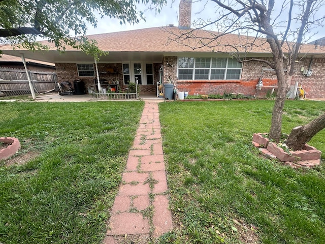 7906 Merchant Dr, Amarillo, TX 79121 - rear view of property featuring brick siding, a yard, a patio, and fence