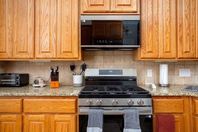 8103 El Paso Dr, Amarillo, TX 79118 - kitchen featuring stainless steel appliances, decorative backsplash, light stone counters, and brown cabinets