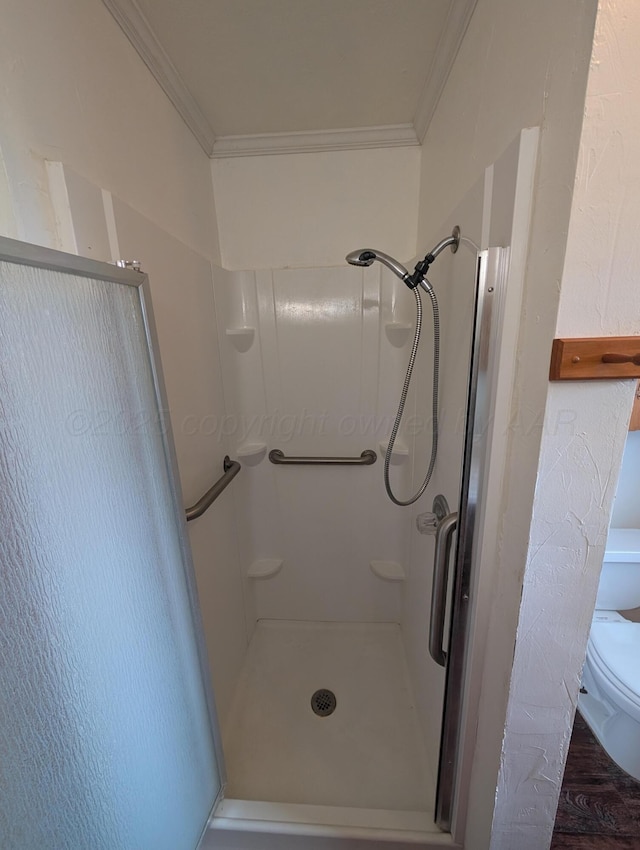 bathroom featuring toilet, ornamental molding, and walk in shower