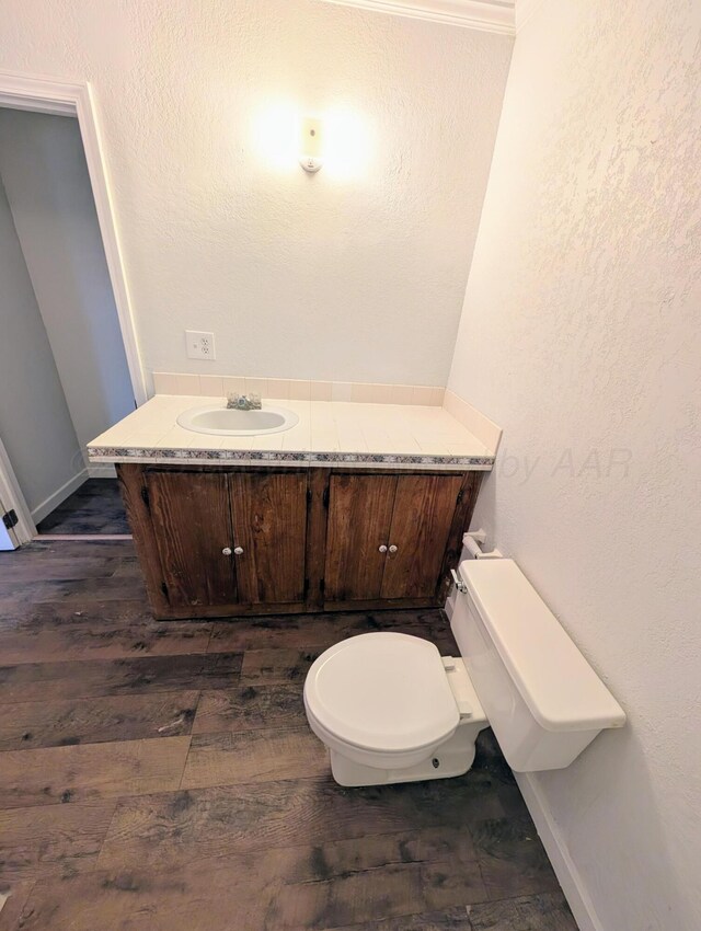 bathroom with hardwood / wood-style flooring, vanity, and toilet