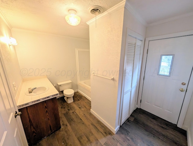 full bathroom with hardwood / wood-style floors, vanity, crown molding, toilet, and bathtub / shower combination