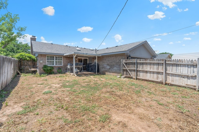 1321 Buena Vista St, Amarillo, TX 79106 - back of property featuring brick siding, a fenced backyard, a chimney, and a patio area