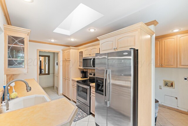 1321 Buena Vista St, Amarillo, TX 79106 - kitchen featuring stainless steel appliances, light brown cabinets, a skylight, light tile patterned floors, and recessed lighting