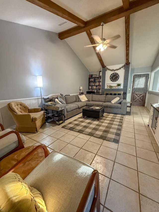 living area featuring light tile patterned floors, visible vents, lofted ceiling with beams, and a ceiling fan