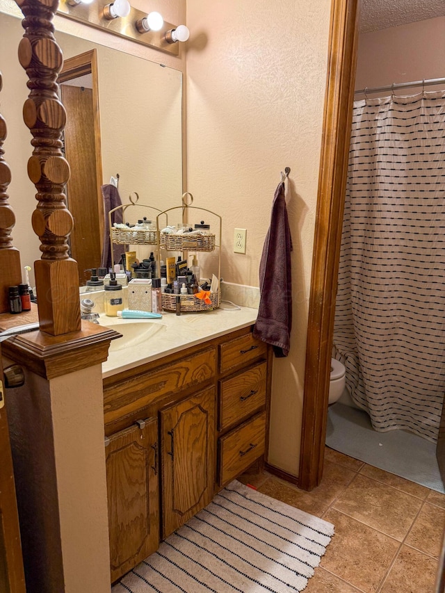 full bathroom featuring vanity, tile patterned flooring, a textured ceiling, curtained shower, and toilet