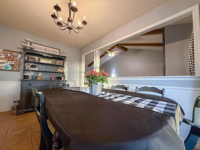 tiled dining area with ceiling fan with notable chandelier, a textured ceiling, and lofted ceiling with beams