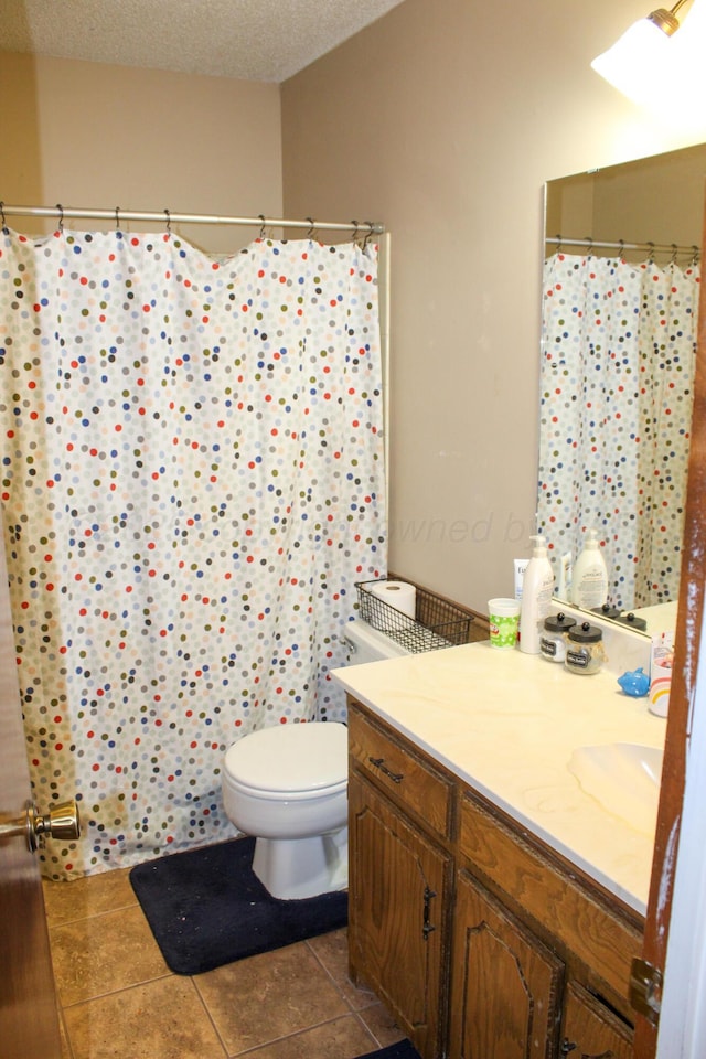 bathroom featuring tile patterned floors, a shower with curtain, toilet, a textured ceiling, and vanity