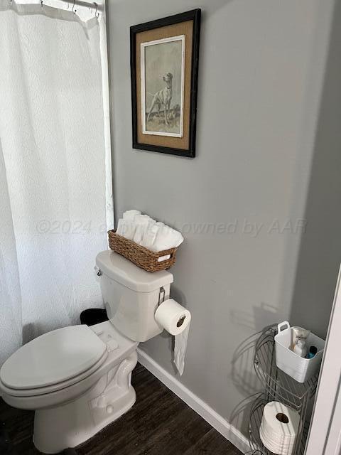 823 S Palo Duro St, Amarillo, TX 79106 - bathroom with baseboards, toilet, wood finished floors, and a shower with curtain