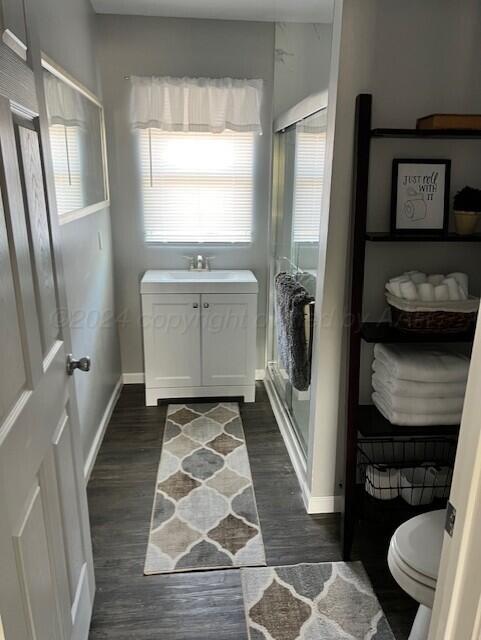 823 S Palo Duro St, Amarillo, TX 79106 - bathroom featuring healthy amount of natural light, a shower stall, wood finished floors, and toilet