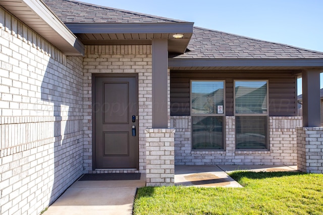 view of exterior entry with a lawn