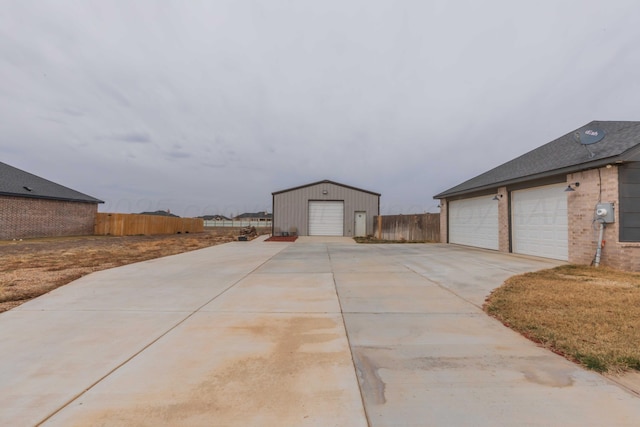 exterior space with fence, an outdoor structure, and a garage