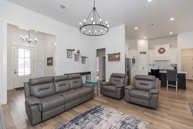 living area with recessed lighting, visible vents, a notable chandelier, and light wood-style floors