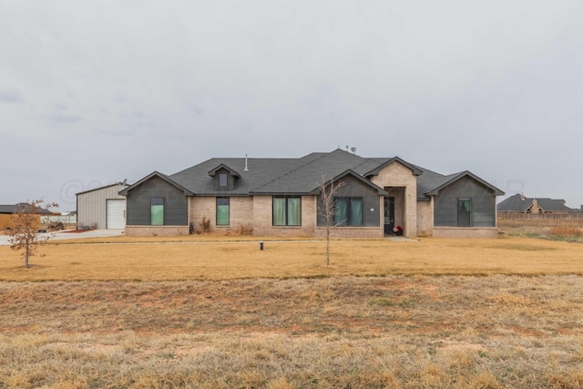 view of front of home featuring a garage, brick siding, a front lawn, and roof with shingles